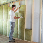 Quels matériaux choisir pour une bonne isolation thermique ? Technicien en train de poser de la mousse isolation sur les murs