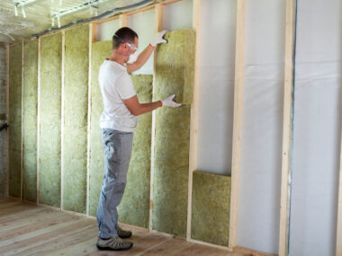 Technicien en train de poser de la mousse isolation sur les murs