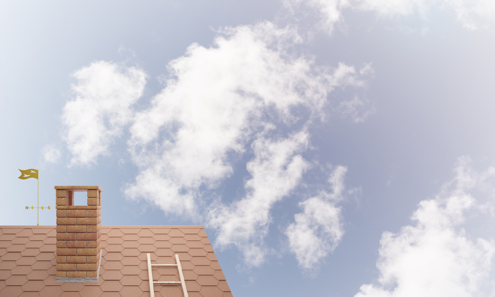 Sortie de cheminée en briques sur toit en pente