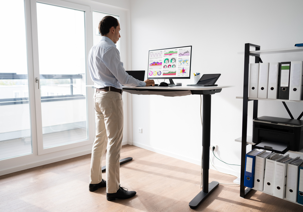 Homme en train de travailler debout pendant sa journée de télétravail