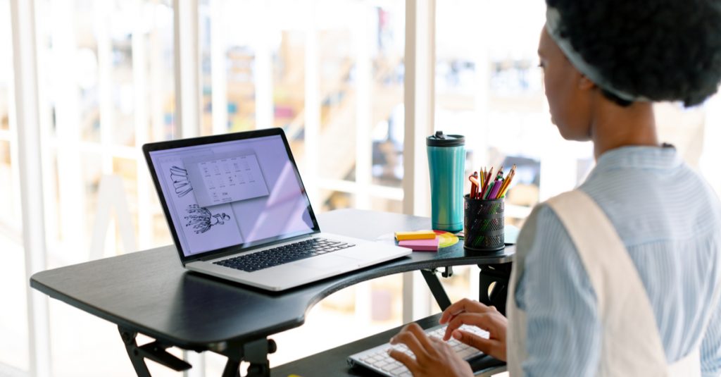 Femme en train de travailler sur son ordinateur portable surélevé avec clavier indépendant
