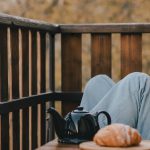 Jeune femme buvant un thé sur sa terrasse d'automne