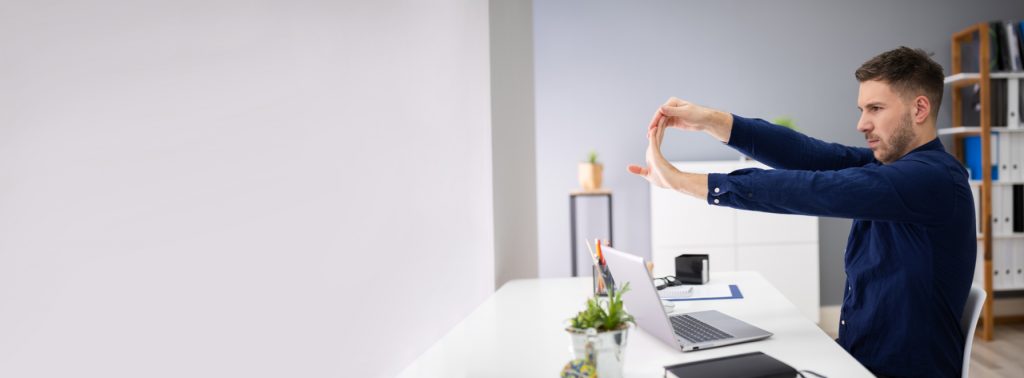 Homme en train de s'étirer pendant le télétravail
