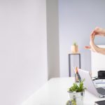 Homme en train de s'étirer pendant le télétravail