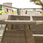 Balcon avec plantes et mobilier en rotin