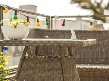 Balcon avec plantes et mobilier en rotin