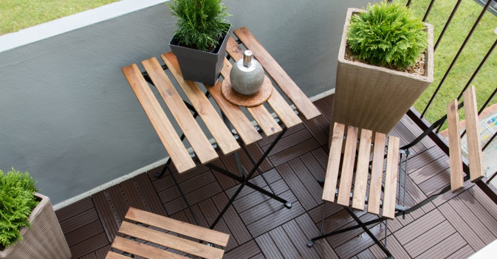 Table en bois et chaises pliantes assorties vues de haut sur un balcon
