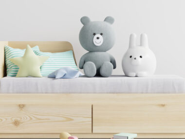 Chambre d’enfant avec peluches et accessoires sur banquette lit