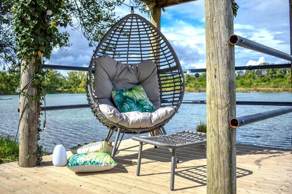 Fauteuil cocon et repose-pied jardin détente sur terrasse en bois