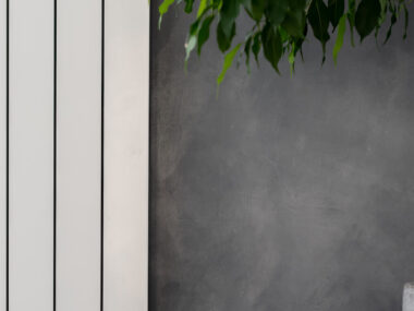Radiateur électrique vertical sur mur de salon gris