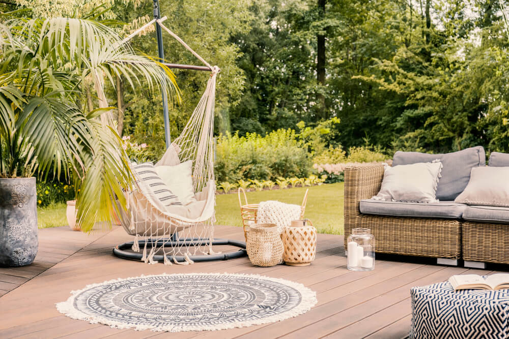 Terrasse en bois avec hamac, tapis et canapé en rotin