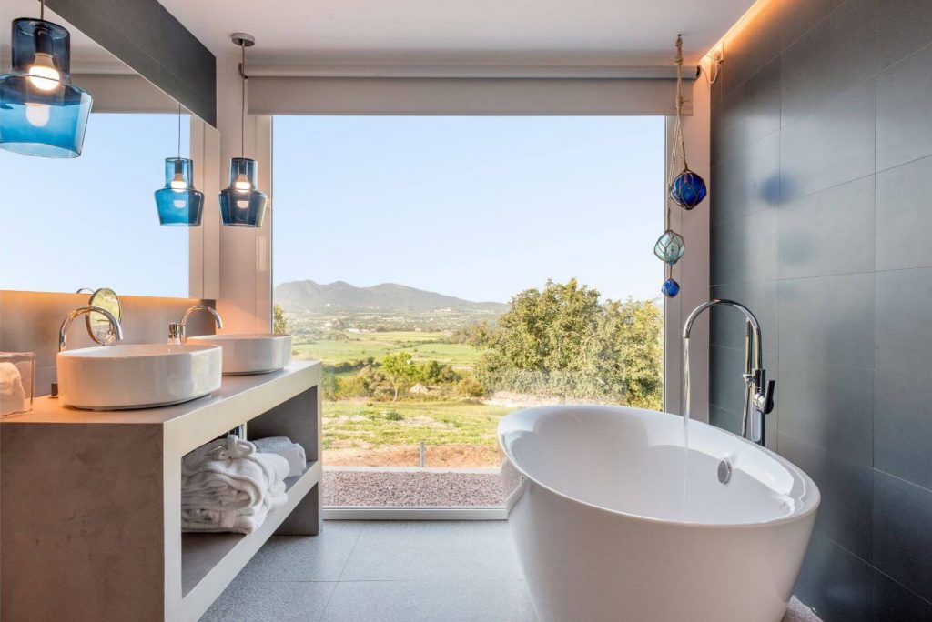 Salle de bain moderne avec baie vitrée ouverte sur un paysage