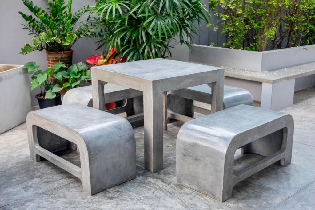 Salon de jardin avec une table et quatre chaises en béton cellulaire