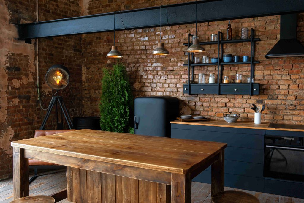 Salon et salle à manger avec table en bois massif, mur en briques et meubles en métal noir