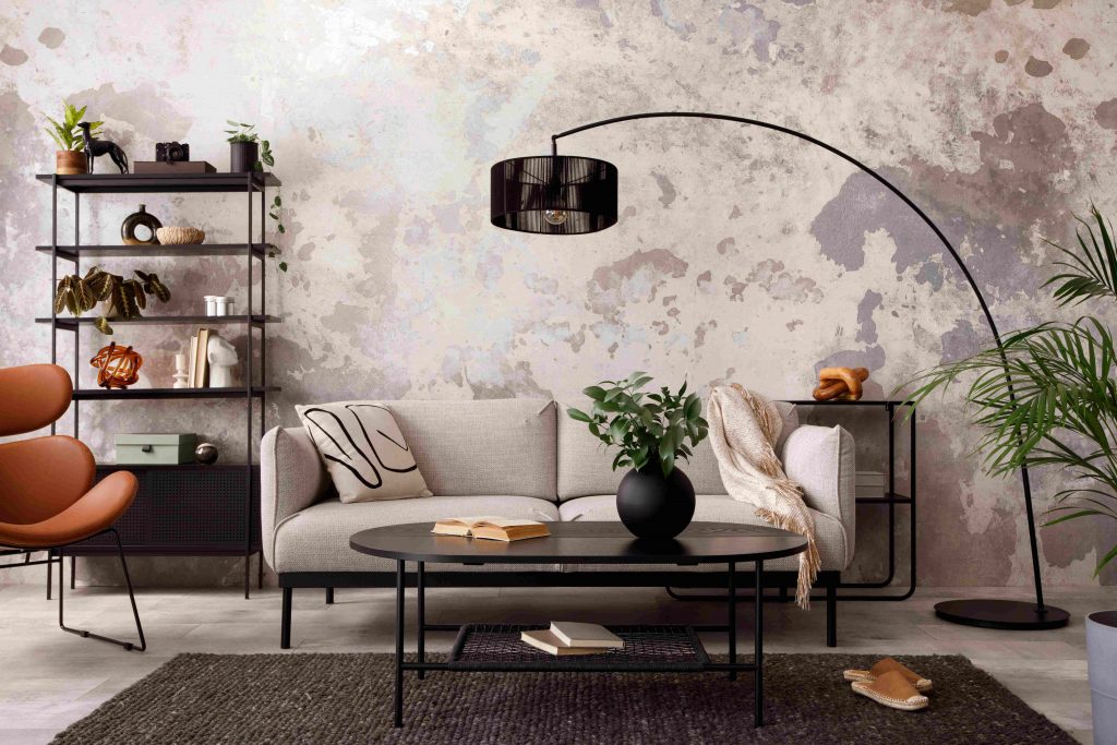 Salon industriel bohème avec mur en béton décoré et canapé beige