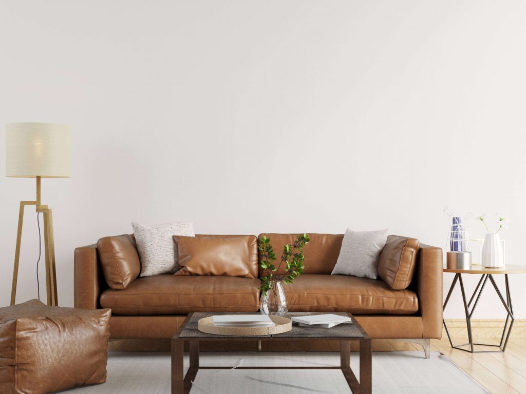 Salon industriel scandinave avec mur blanc, canapé en cuir marron et table basse en bois